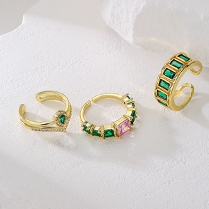 18K gold plated ring set with green and pink zircon gemstones on a white stone background