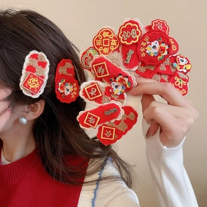 Detail of red plush hair clips with Year of the Horse embroidery and Lucky character