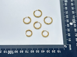 Close-up detail of six gold textured hoop earrings showing 15mm diameter size on ruler