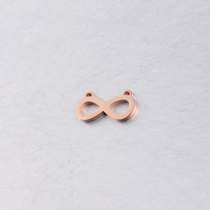 Macro-opname van roségouden infinity-bedels met gepolijste roestvrijstalen afwerking