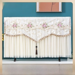 Close-up of linen microwave dust cover with floral embroidery and tassel fringe