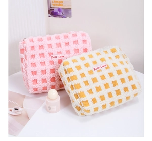 Detail of waffle plush checkered makeup bags in pink and yellow with soft furry texture