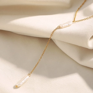 Detailed macro view of 18K gold plated Y-shaped necklace with baroque pearl tassels