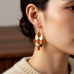 Macro view of vintage style 18K gold plated drop earrings with amber glass teardrop