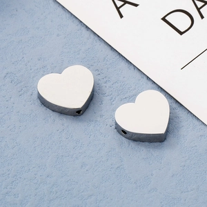 Dettaglio delle perle a cuore in acciaio inossidabile lucido per la creazione di gioielli