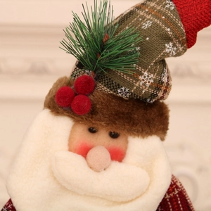 Close-up of Santa Claus plush ornament showing detailed linen, faux fur, and pine needles