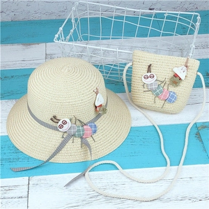 Close-up of kids straw sun hat and matching bag with colorful caterpillar decoration