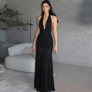 Elegant backless halter dress in black polka dot mesh with a long fishtail silhouette