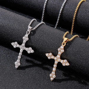 Vue macro de pendentifs croix hip hop en or et argent sertis de cristaux brillants