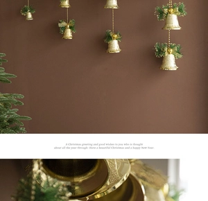 Close-up of golden Christmas bells with pine needles and festive holiday ornaments