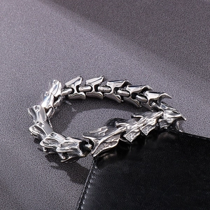 Gros plan d'un bracelet en acier argenté vintage à maillons de dragon avec texture vieillie