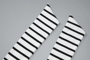 Close-up of black and white striped ribbed knit fabric with detailed texture and lacing