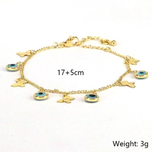 Golden bracelet featuring blue evil eye beads and butterfly pendant on white background