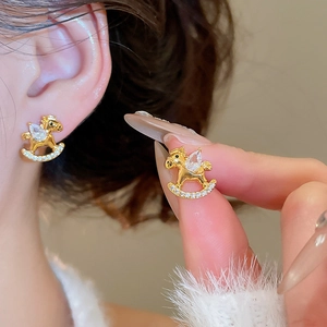 Detailed close-up of gold rocking horse stud earrings with sparkling cubic zirconia stones