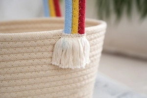 Close-up of woven cotton rope basket featuring colorful handles and elegant tassel details