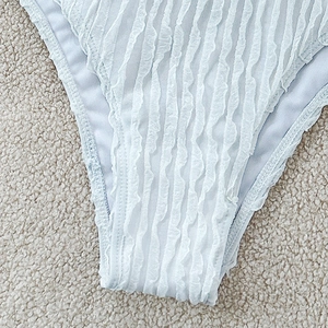 Close-up of light blue bikini bottom with wave texture fabric on white fleece