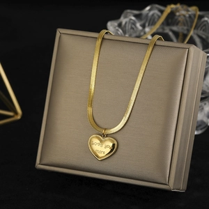 Detail of gold heart pendant with 'love you more' engraving on a sleek snake chain