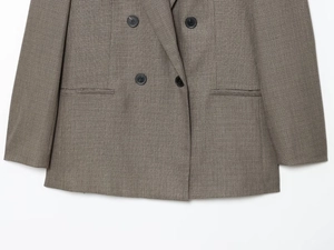 Detailed macro shot of grey double-breasted blazer buttons and textured woven fabric