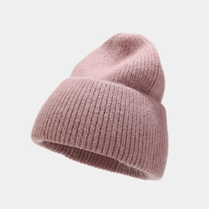 Detailed close-up of pink angora rabbit fur knit beanie with thick vertical ribbing texture