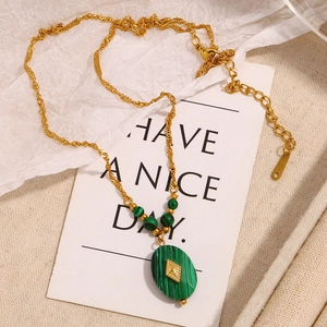 Detail of 18K gold plated necklace with green malachite pendant on decorative card