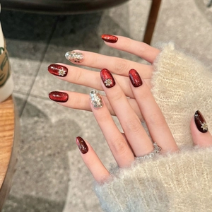 Deep red cat eye press-on nails with 3D flower charms and silver glitter almond shape