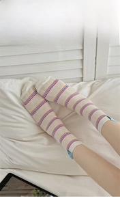Detail of waffle texture and rainbow stripes on beige high-thread count cotton crew socks