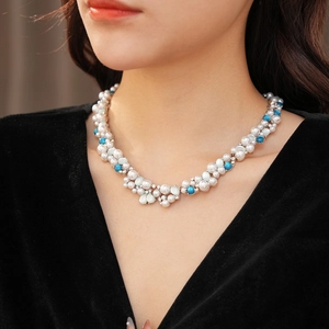 Dettaglio della collana vintage con perle bianche, perline turchesi blu e strass scintillanti