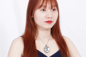 Close-up of model wearing a crystal glass pendant necklace with silver chain detail