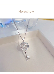 Detailed close-up of a silver key pendant necklace with zircon inlay in a premium gift box