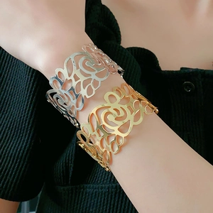 Close-up of hollow rose pattern metal cuff bracelet in gold and silver finish