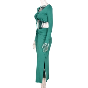 Detail of dark green knit two-piece set with long sleeve crop top and side slit maxi skirt
