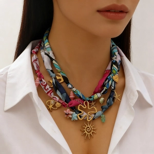 Close-up of three-layer ribbon necklace with gold sun and starfish charms