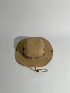Detail of khaki outdoor boonie hat featuring metal eyelets and adjustable chin strap