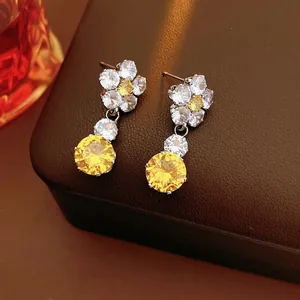 Luxury flower drop earrings with yellow zircon crystals and white diamonds on leather
