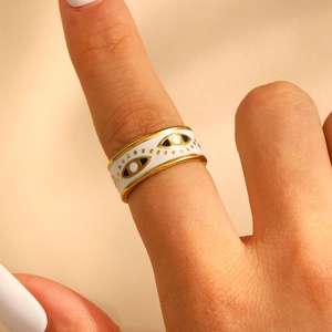 Macro close-up of a vintage evil eye ring featuring white enamel and gold-plated details