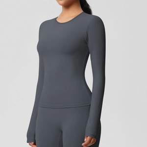 Détail du haut de sport gris à manches longues et du legging de yoga à taille haute