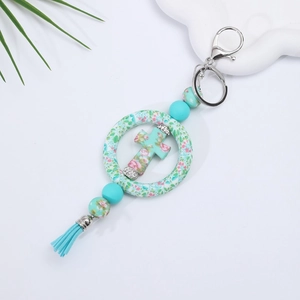 Detail of mint green silicone beads and floral cross pendant with tassel car charm