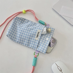 Detailed top view of blue checkered phone bag with pink strap and daily essentials