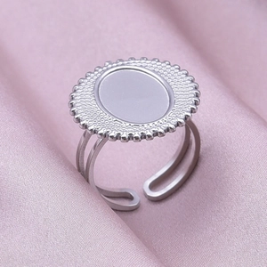 Detail of silver stainless steel adjustable ring with oval face on pink silk