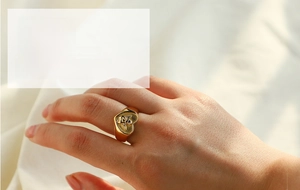 Close-up of 18k gold plated stainless steel heart ring with cupid angel embossing