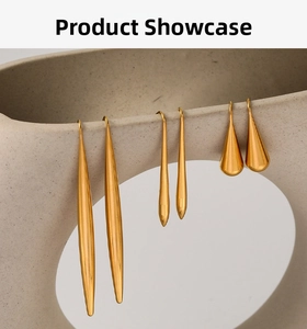 Three pairs of minimalist 18K gold plated stainless steel long drop earrings on beige ceramic