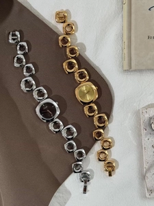 Close-up of gold and silver women's watches with unique irregular hollow chain bracelets