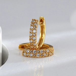 Macro view of gold-plated hoop earrings featuring micro-pave white zircon stones