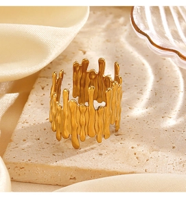 Detailed macro of golden fluid line ring with lava texture on stone and silk background