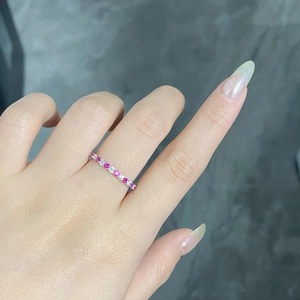 Close-up of S925 silver ring on finger with alternating pink and white round gemstones