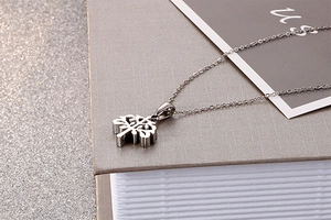 Macro view of a silver Tree of Life hollow pendant on a stainless steel chain