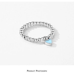 Close-up of S925 sterling silver beaded ring featuring a light blue enamel heart charm