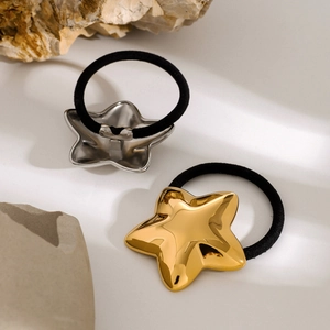 Detailed shot of gold and silver star hair ties on a stone with warm lighting