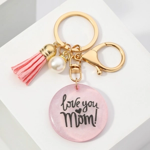 Détail du porte-clés MOM avec pompon rose, perle et inscription love you Mom gravée