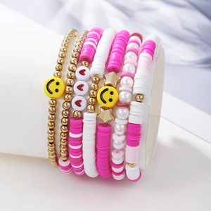 Close-up of stacked bohemian bracelets with pink clay beads and yellow smiley face charms